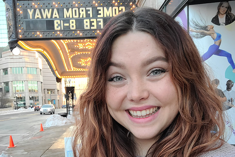 Woman in front of theatre sign