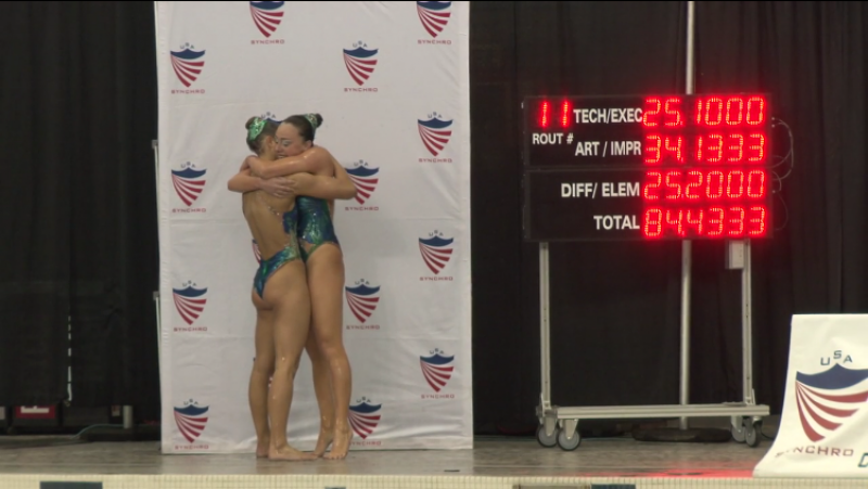 Emma Baranski and Elizabeth Davidson hug poolside after their first place duet performance