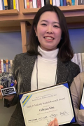 Gillian Kim stands with award