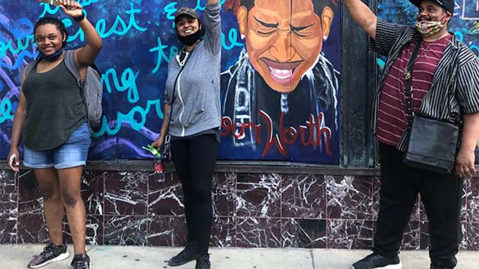 Artists standing in front of mural