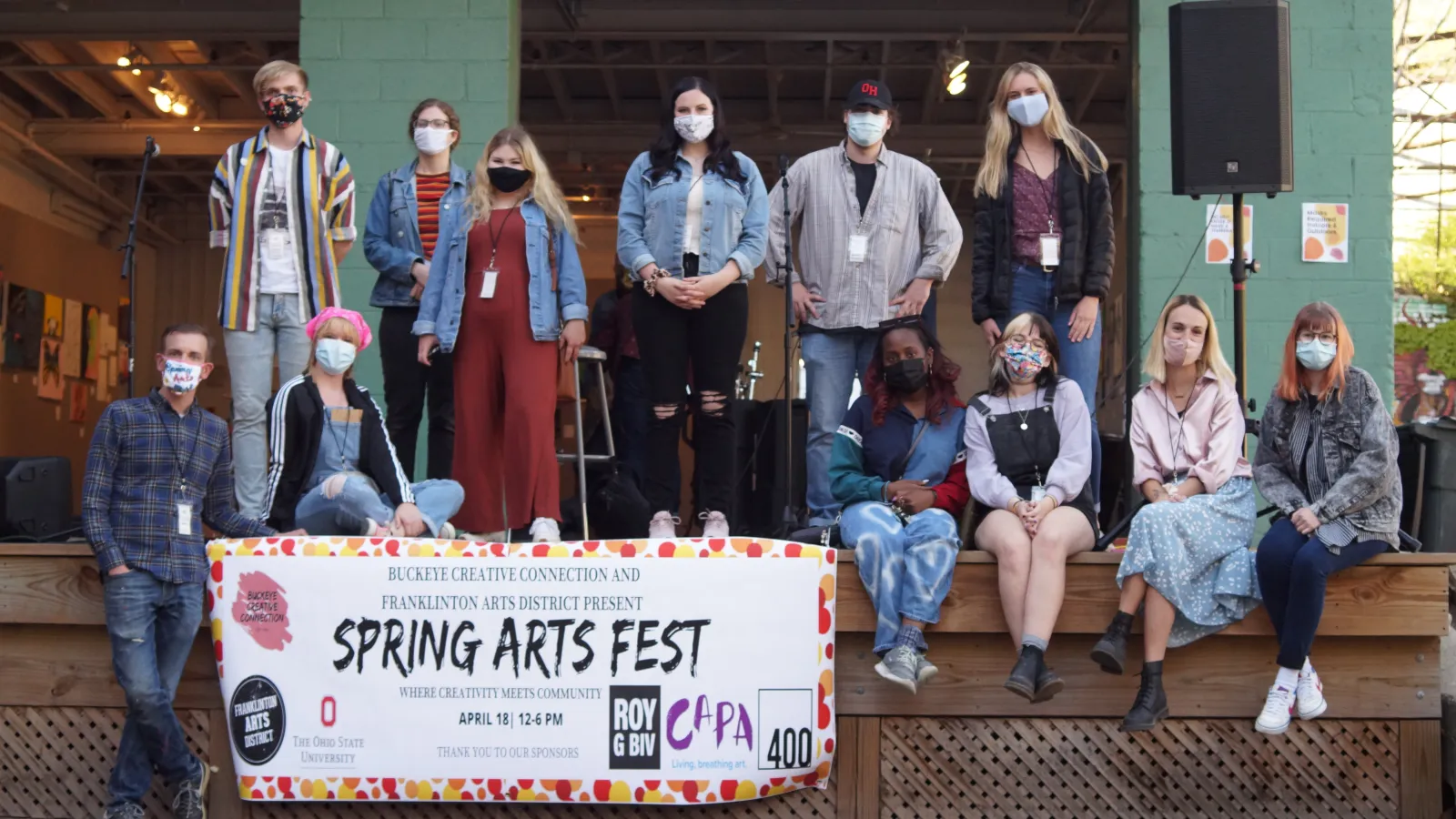 Students pose on stage in front of open outdoor space