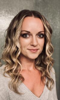 Woman with blond curls looking at camera