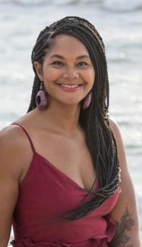 Picture of woman smiling at camera in front of water