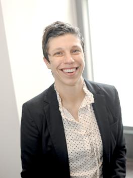 Woman smiling at camera, wearing a polka dot shirt and jacket