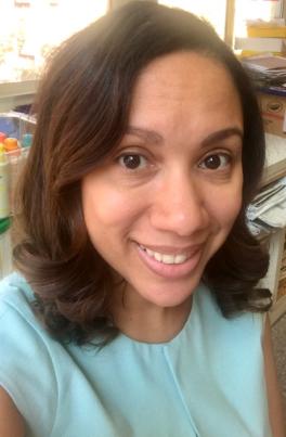 Woman in teal shirt smiling at camera