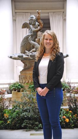 Woman smiling at camera in front of statue.