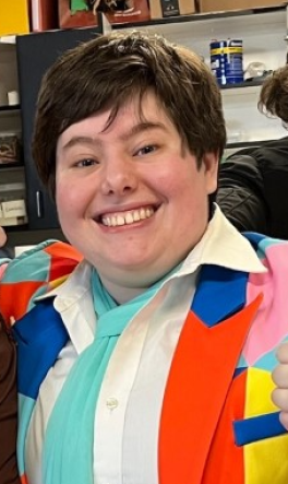 Anna Vigorito smiles at camera wearing brightly colored shirt