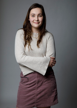 Woman in beige shirt smiling at camera