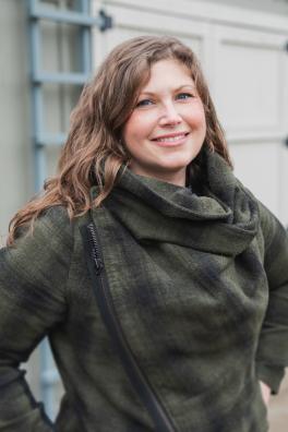 Woman wearing plaid shirt, smiling at camera