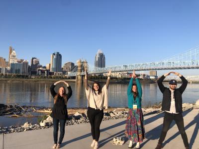 Students spell Ohio with arms in front of river and bridge