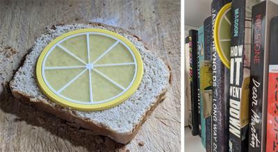 A plastic yellow lemon on wheat bread and a plastic yellow lemon wedged between books on a shelf.