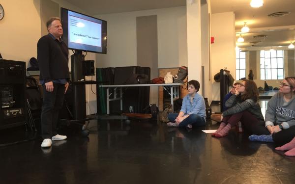 students and instructor in front of TV