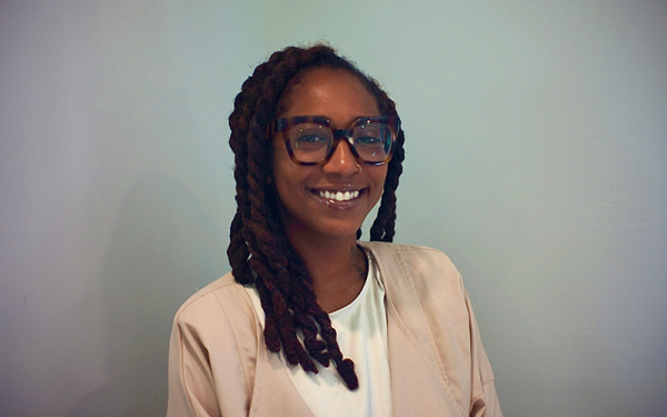 A woman with glasses smiles at camera