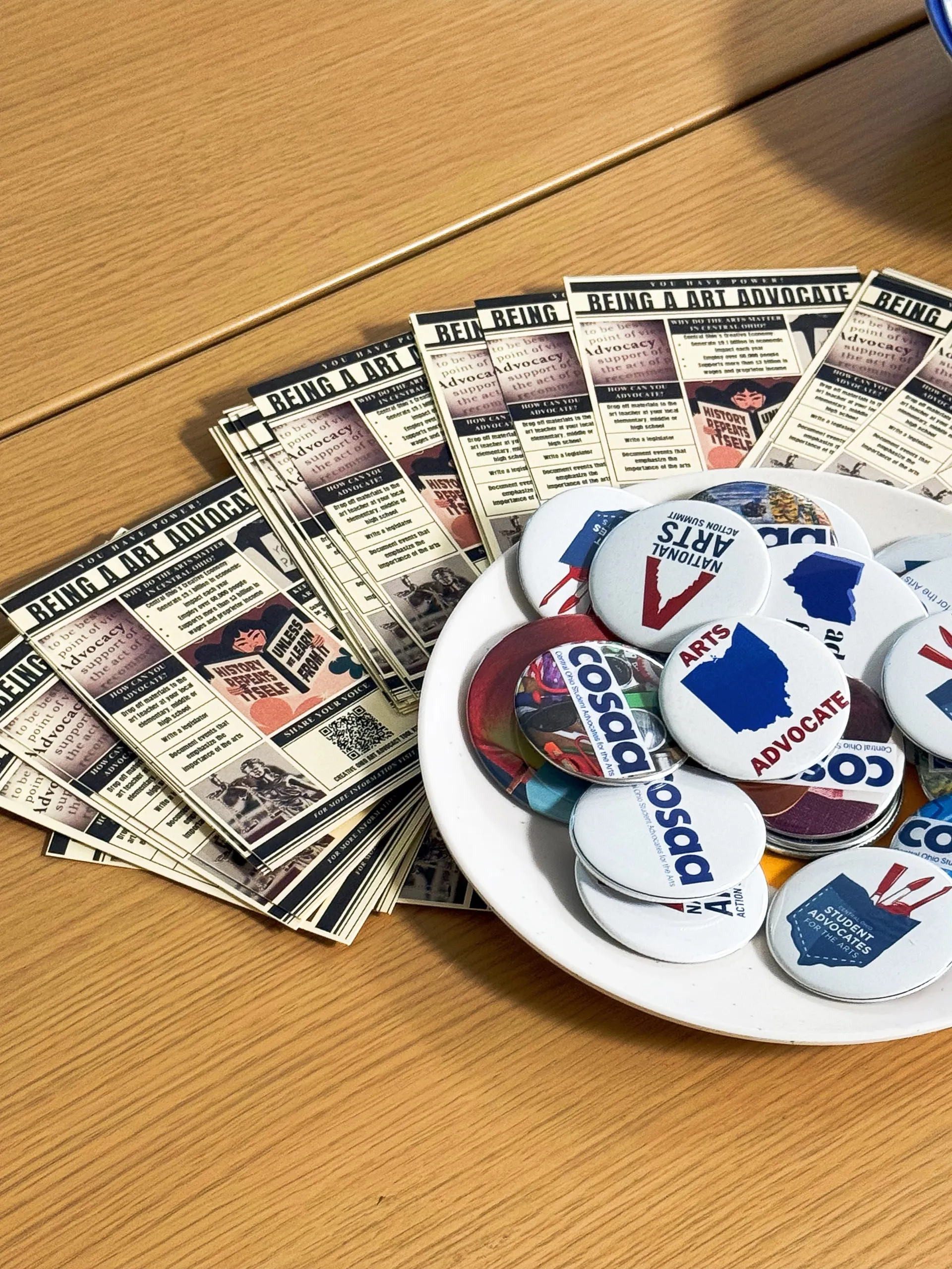 Pamphlets and buttons about arts advocacy