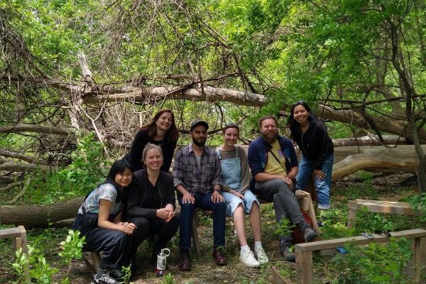 Students and instructor smile at camera in front of the Don River
