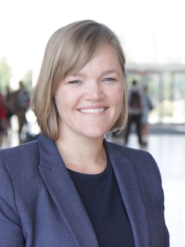 A headshot of a woman standing in lobby of building