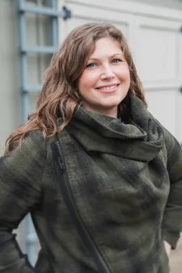 Woman wearing plaid shirt, smiling at camera